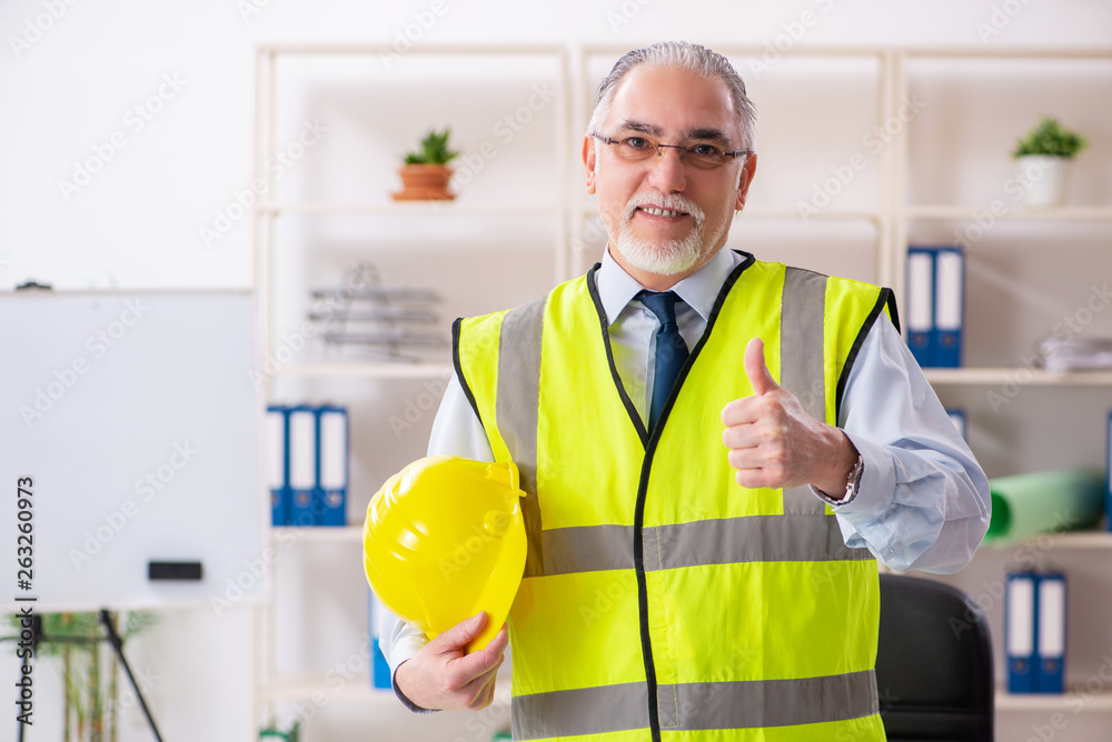 Aged construction engineer working in the office Aged construction engineer working in the office