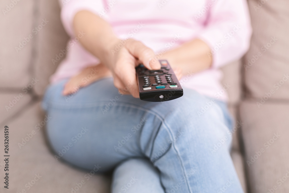 Senior woman changing channels on tv with remote control Senior woman changing channels on tv with remote control