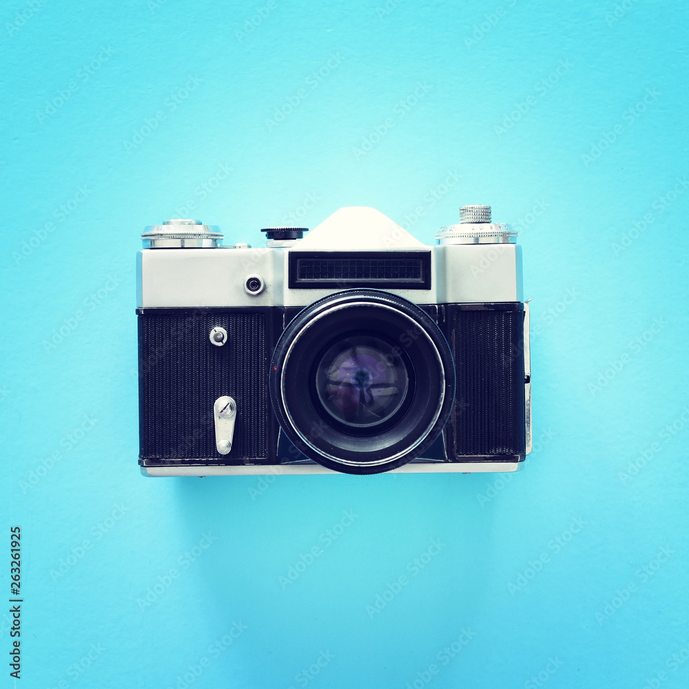 Top view of old photo camera over blue background