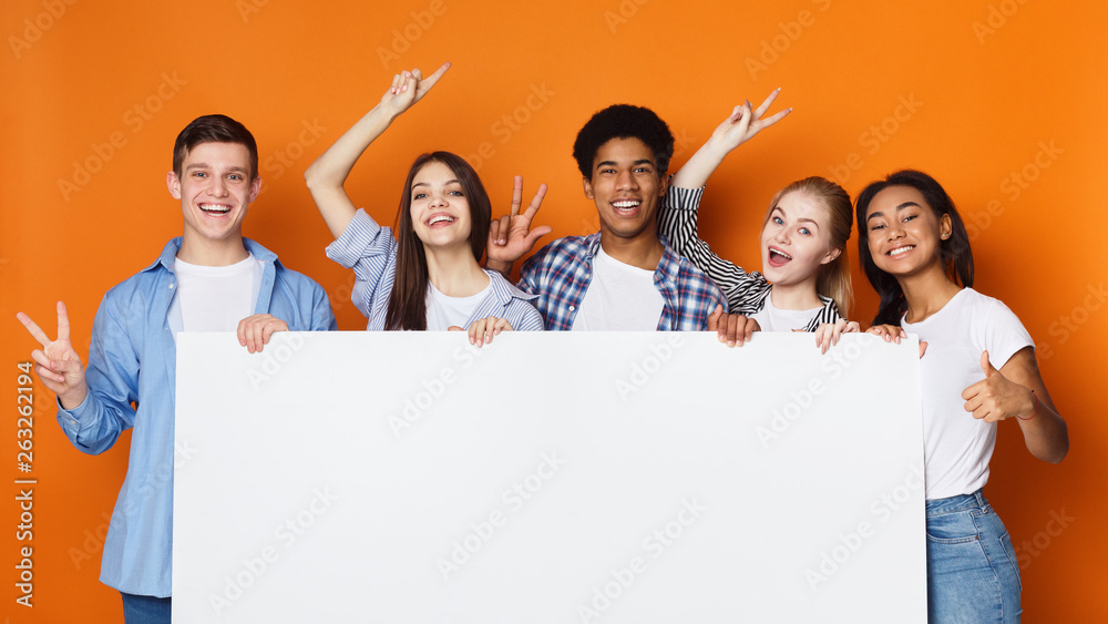 Happy friends holding empty banner, orange background Happy friends holding empty banner, orange background