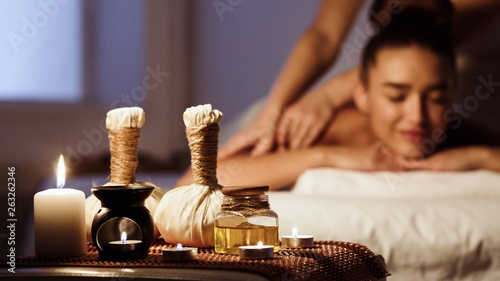 Schilderij op canvas Woman relaxing in spa salon with herbal bags on wooden tray