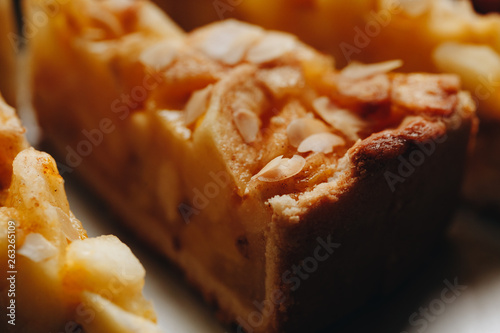 a piece of delicious fresh Apple pie with cinnamon on a white plate in the restaurant close-up