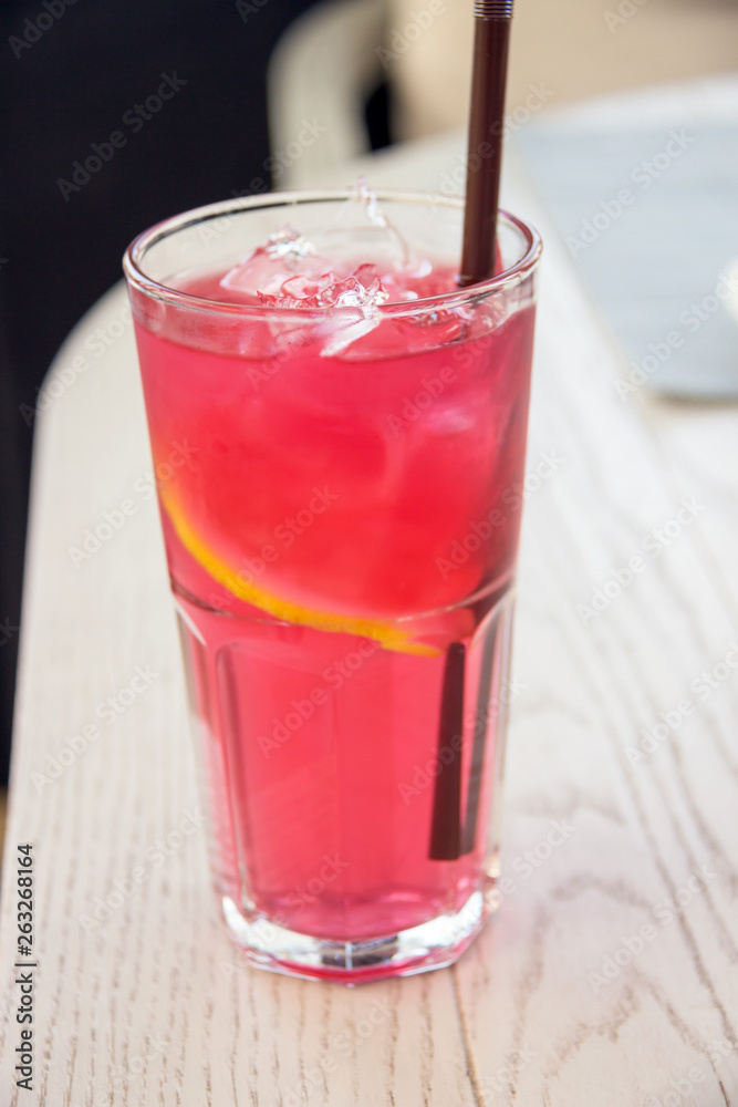 Iced rose and berries tea with lemon sliced on light brown table. Cold mocktail. Iced rose and berries tea with lemon sliced on light brown table. Cold mocktail.