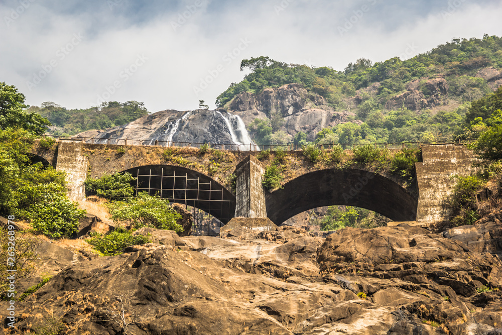Railway bridge over the river Mandovi on the background of the Dudhsagar waterfall