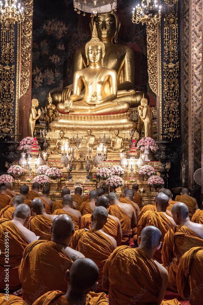 Buddhist monks pray to Buddha inside Wat Bowonniwet Vihara, Bangkok, Thailand
