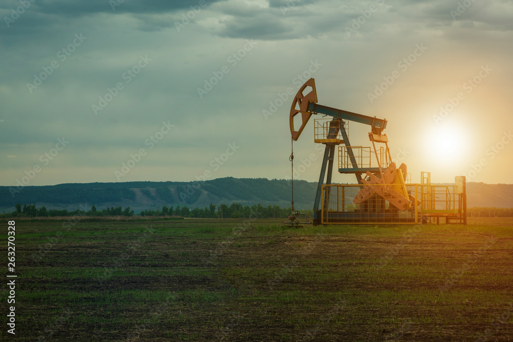 oil pump on the background of nature. the landscape of oil production. oil market. oil pump on the background of nature. the landscape of oil production. oil market.