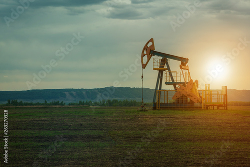 oil pump on the background of nature. the landscape of oil production. oil market. photo