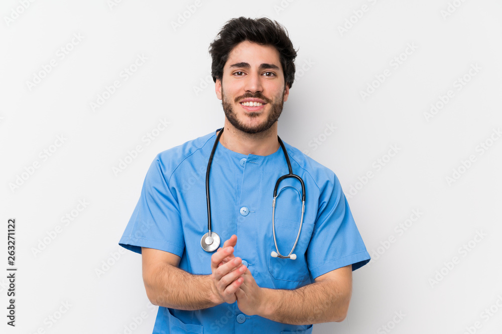 Surgeon doctor man over isolated white wall applauding Surgeon doctor man over isolated white wall applauding