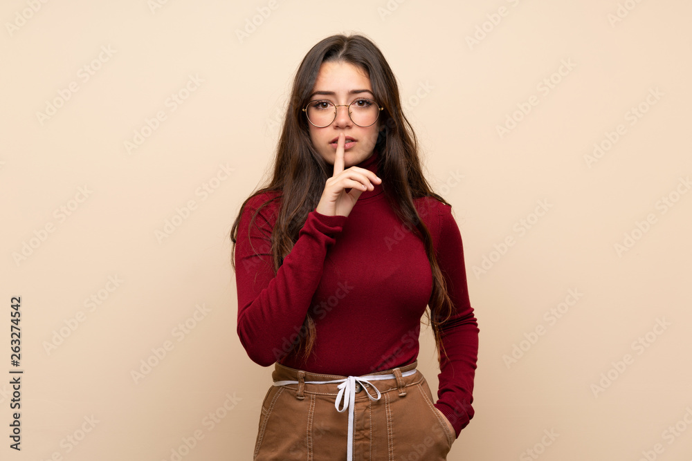Teenager girl with glasses showing a sign of silence gesture putting finger in mouth Teenager girl with glasses showing a sign of silence gesture putting finger in mouth