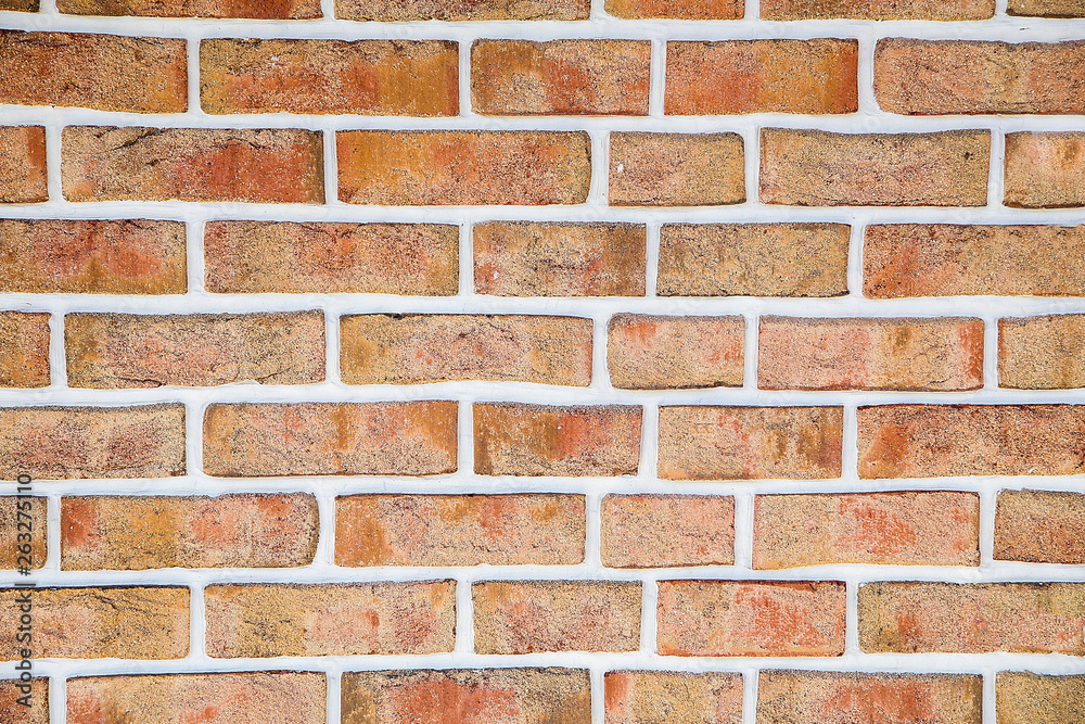 Obraz premium The brick wall of the cracked decorative brick is red .Texture.Background.