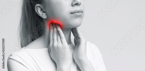A picture of a young woman suffering from tonsillities over white background photo