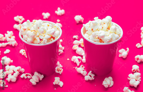 Pop corn in red paper cups on pink color background