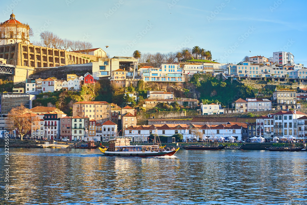 Boats on Douro river with view on  Red roofs of side Villa Nova de Gaia  in Porto. Concept of world travel, sightseeing and tourism