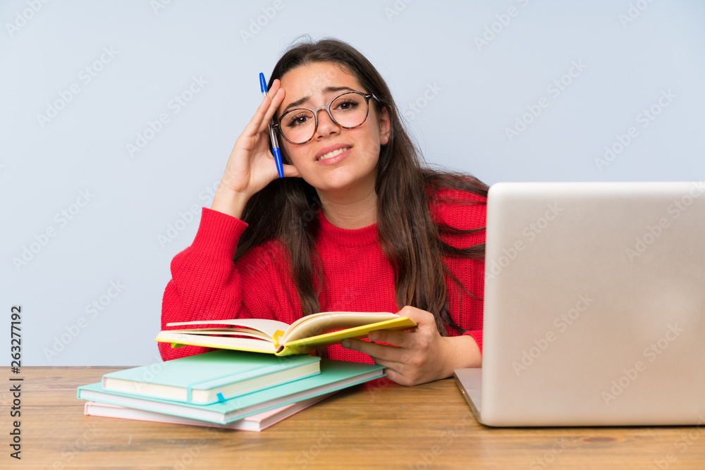 Frustrated Teenager student girl studying in a table Frustrated Teenager student girl studying in a table