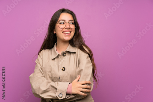 Teenager girl over purple wall laughing © luismolinero
