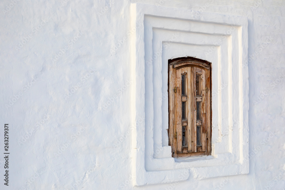 Fototapeta premium Old small wooden window with a poor light