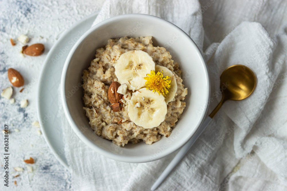 oatmeal porridge with banana and almond, top view oatmeal porridge with banana and almond, top view