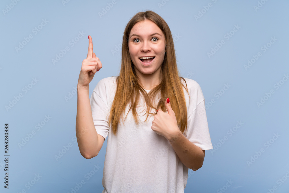 Young woman over blue wall with surprise and shocked facial expression Young woman over blue wall with surprise and shocked facial expression