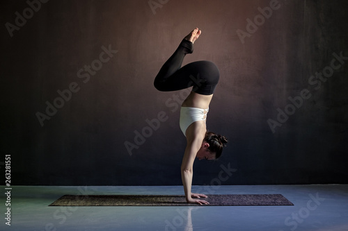 woman practicing yoga, Adho Mukha Vrksasana exercise, Downward facing Tree pose