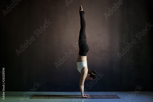 Canvas-taulu woman practicing yoga, Adho Mukha Vrksasana exercise, Downward facing Tree pose