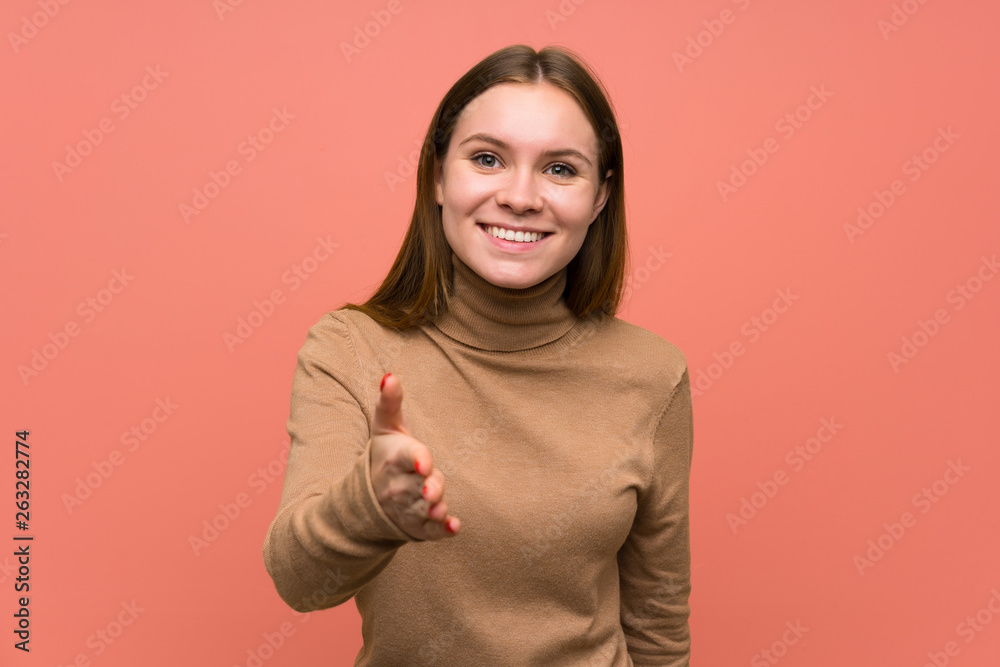 Young woman over colorful background handshaking after good deal Young woman over colorful background handshaking after good deal