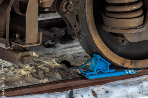 Train is secured with brake shoe. Safety rules.