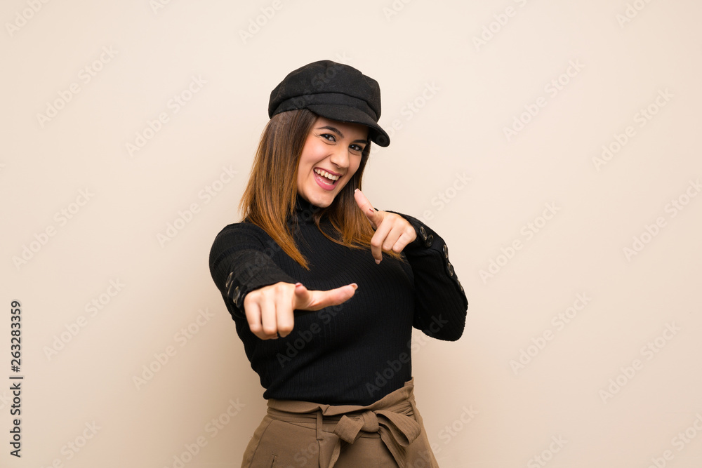 Fashion woman with hat pointing to the front and smiling Fashion woman with hat pointing to the front and smiling