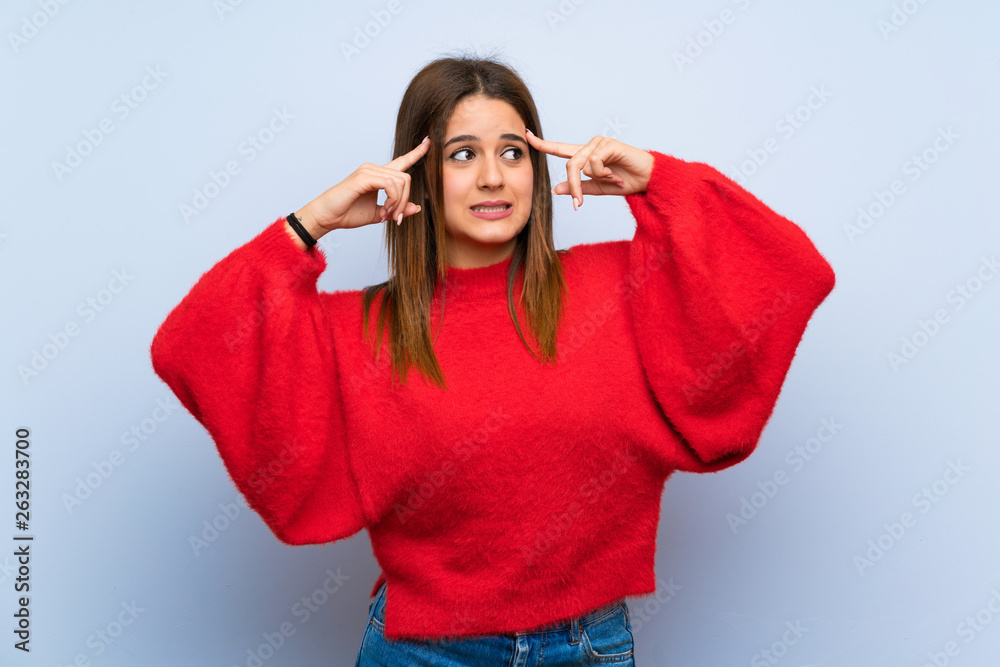 Young woman over isolated blue wall having doubts and thinking Young woman over isolated blue wall having doubts and thinking