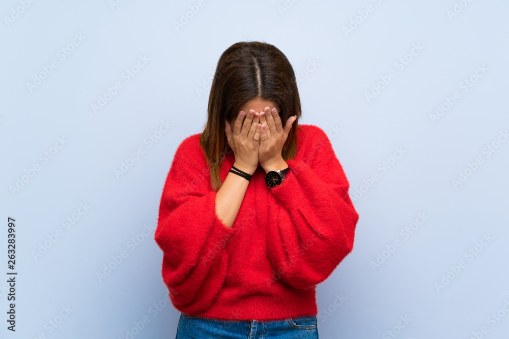 Young woman over isolated blue wall with tired and sick expression Young woman over isolated blue wall with tired and sick expression