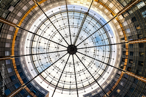 Round building with suspended transparent outdoor ceiling reflected the sky during the sunset moment