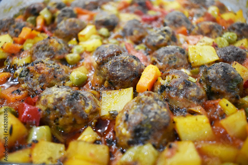 on marble floor, meatballs with vegetables, in glass baking dish
