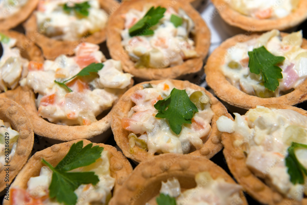Fish and meat salads in tartlets on a plate. Fish and meat salads in tartlets on a plate.