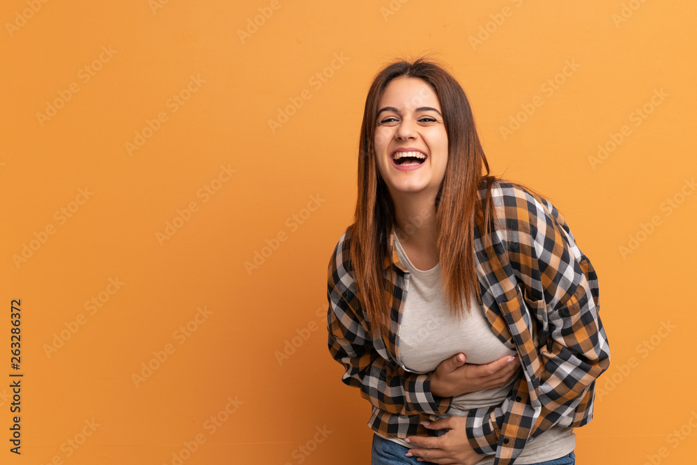 Young woman over brown wall smiling a lot Young woman over brown wall smiling a lot