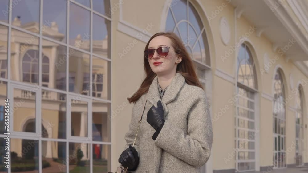 Businesswoman is walking to work in morning time, moving along buildings Businesswoman is walking to work in morning time, moving along buildings