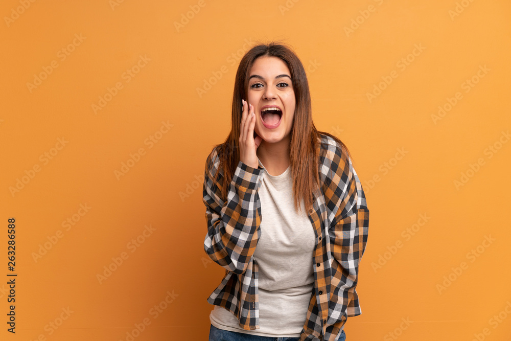 Young woman over brown wall with surprise and shocked facial expression Young woman over brown wall with surprise and shocked facial expression