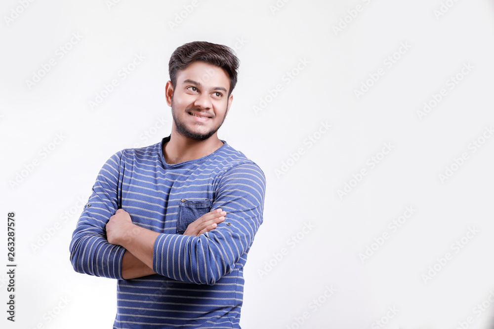 Handsome young Indian man standing with hands folded isolated over white background