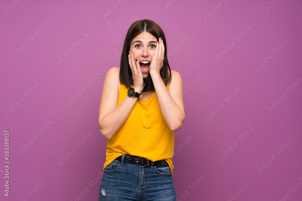Young woman over isolated purple wall with surprise and shocked facial expression Young woman over isolated purple wall with surprise and shocked facial expression
