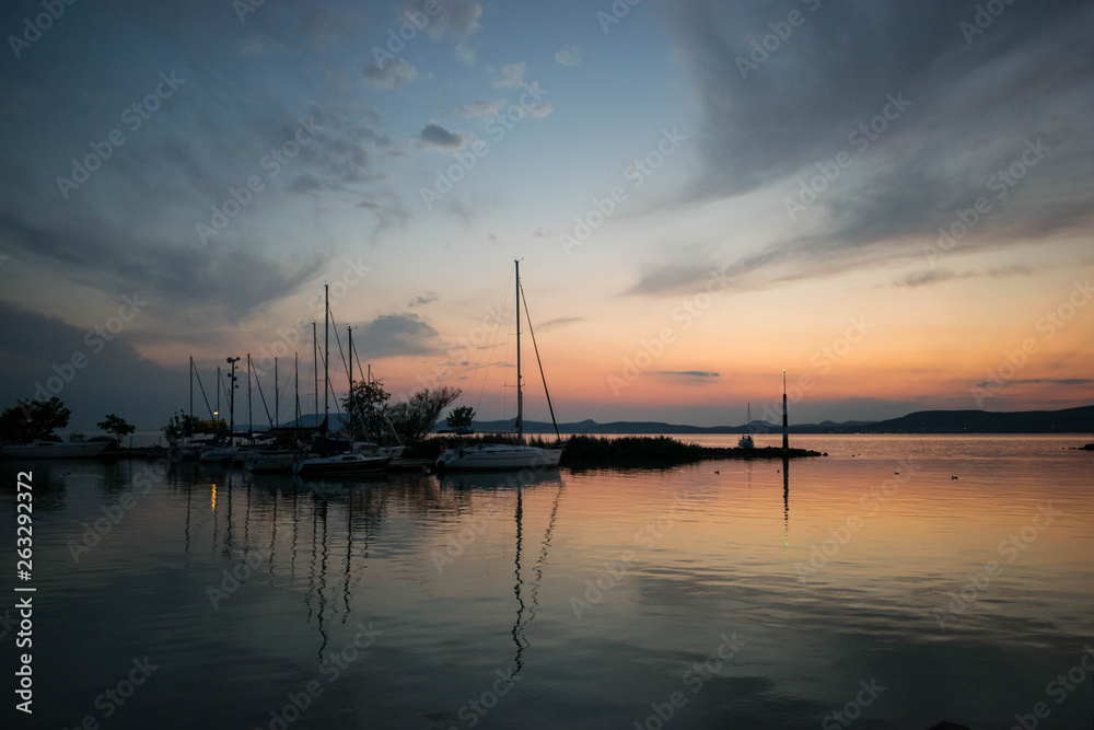 Sunset on lake Balaton, Hungary, which gives place to the blue ribbon international competition each year and also presented with the reflection of the humbling boats in the foreground.