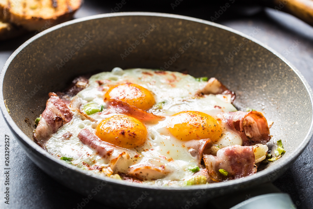 English breakfast fried bacon ham and eggs in ceramic pan English breakfast fried bacon ham and eggs in ceramic pan