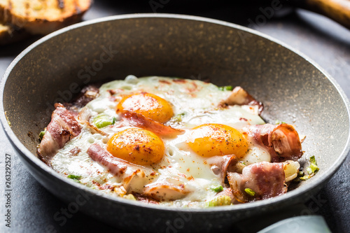 English breakfast fried bacon ham and eggs in ceramic pan