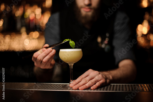 Close-up of bartender pouring cocktail using forceps