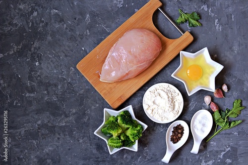 ngredients for cooking chopped chicken cutlets or rissole with broccoli: raw chicken, broccoli, wheat flour, egg, salt, pepper, garlic, parsley. Top view, copy space. photo