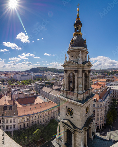 Steeple of St. Stephen's Cathedral with the sun on high and the clear sky, Budapest, Hungary photo