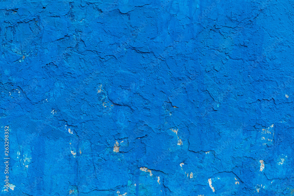 Impressive background. The surface has a multilayered plaster covering. The paint of blue color which cracked in places Impressive background. The surface has a multilayered plaster covering. The paint of blue color which cracked in places