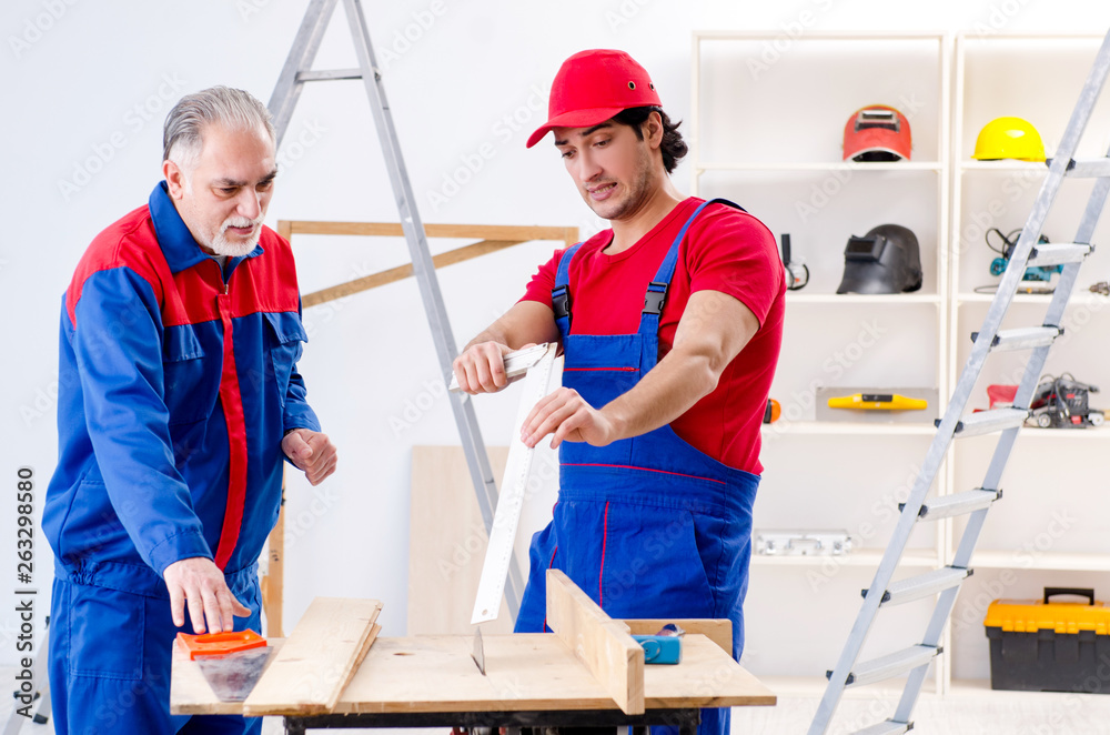 Two professional contractors laying flooring at home Two professional contractors laying flooring at home