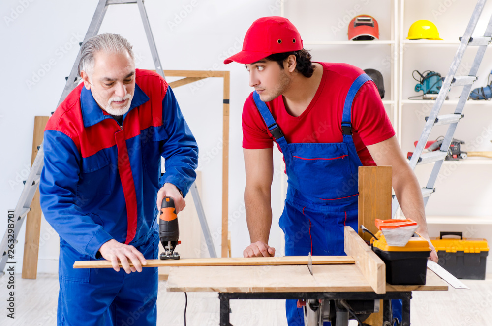 Two professional contractors laying flooring at home Two professional contractors laying flooring at home