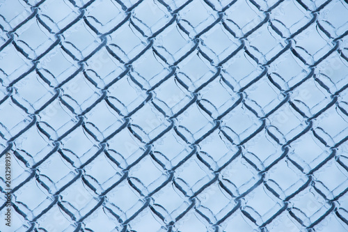 Abstract background with ice on metal fence