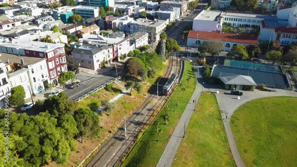 Drone Aerial of Muni Metro Train in San Francisco California With Railway Tennis Courts and Baseball Field Drone Aerial of Muni Metro Train in San Francisco California With Railway Tennis Courts and Baseball Field