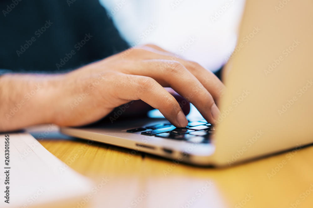 Sideview of businessman using laptop on desk top Sideview of businessman using laptop on desk top