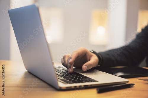 Sideview of man using notebook on desktop
